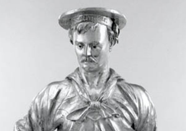 Full figure of a man in sailors uniform with hat. Figure has right hand on hip and left hand at side. Base has inscription 