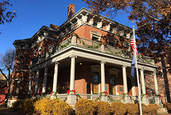 image of the presidential site during fall, garland is draped along the porch, the sky is very blue