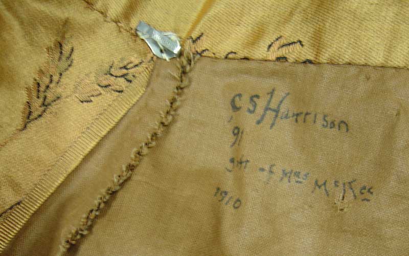 This close up of Caroline's gold dress shows an inscription on the inside that reads, 
