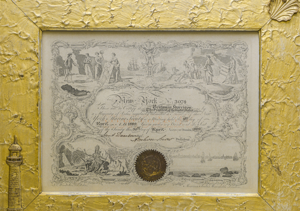Framed Certificate New York Marine Society in wooden frame. Embellishments on frame: eagle at top center, rope knot in upper left corner, anchor and rope in lower right corner, bust of George Washington with leaf and berry design around Washington. Inner frame wooded frame is gold leaf and a shell in upper right and lighthouse on lower left. The outside edge of the frame is rope painted and linked chain design on inner part of outer frame. 9