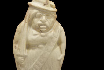 Ivory colored flask that depicts Teddy Roosevelt wearing sash that says 