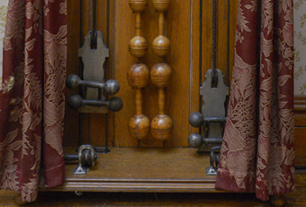 Oak case with iron dumbbell shaped weights (5) on ropes to be pulled, eight sets of wooden dumbbells and pair of Indian clubs. Metal plate: 