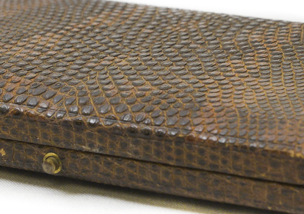 A brown box that has the appearance of being made from snakeskin; box opens up and medals swing out to prop the top up as a display case; two medals inside-one is intended for the President of the United States of America and the other is intended for the President of the United States of Mexico. Marked: 
